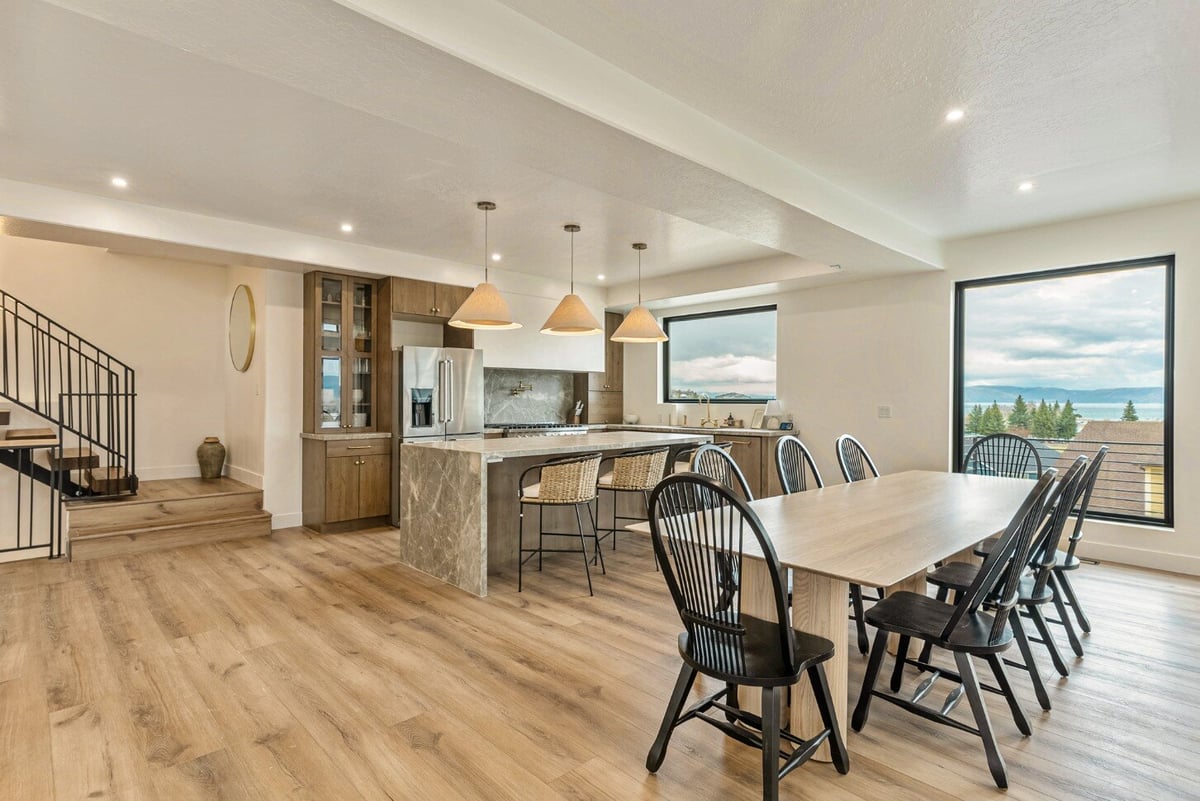 Dining Area with Large Window and Kitchen in Bear Lake Custom Home by 10X Builders