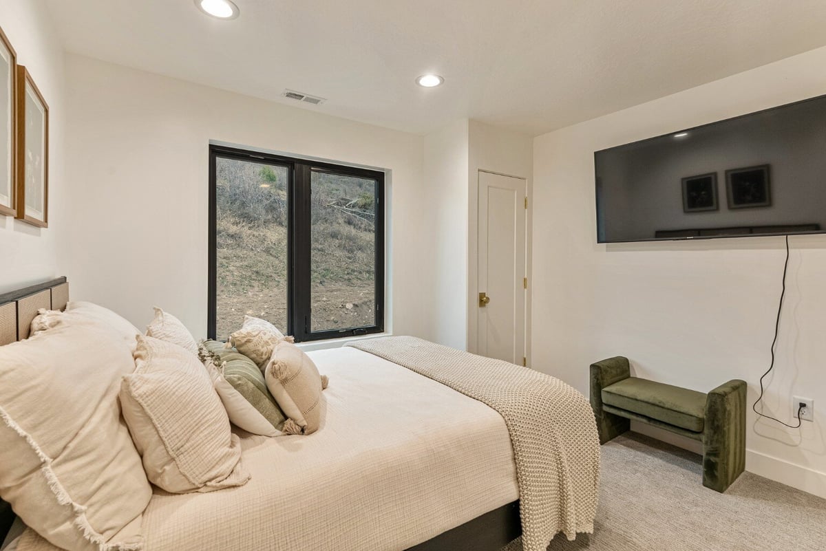 Guest Bedroom with Small Window, Closet and Television in Bear Lake Custom Home by 10X Builders