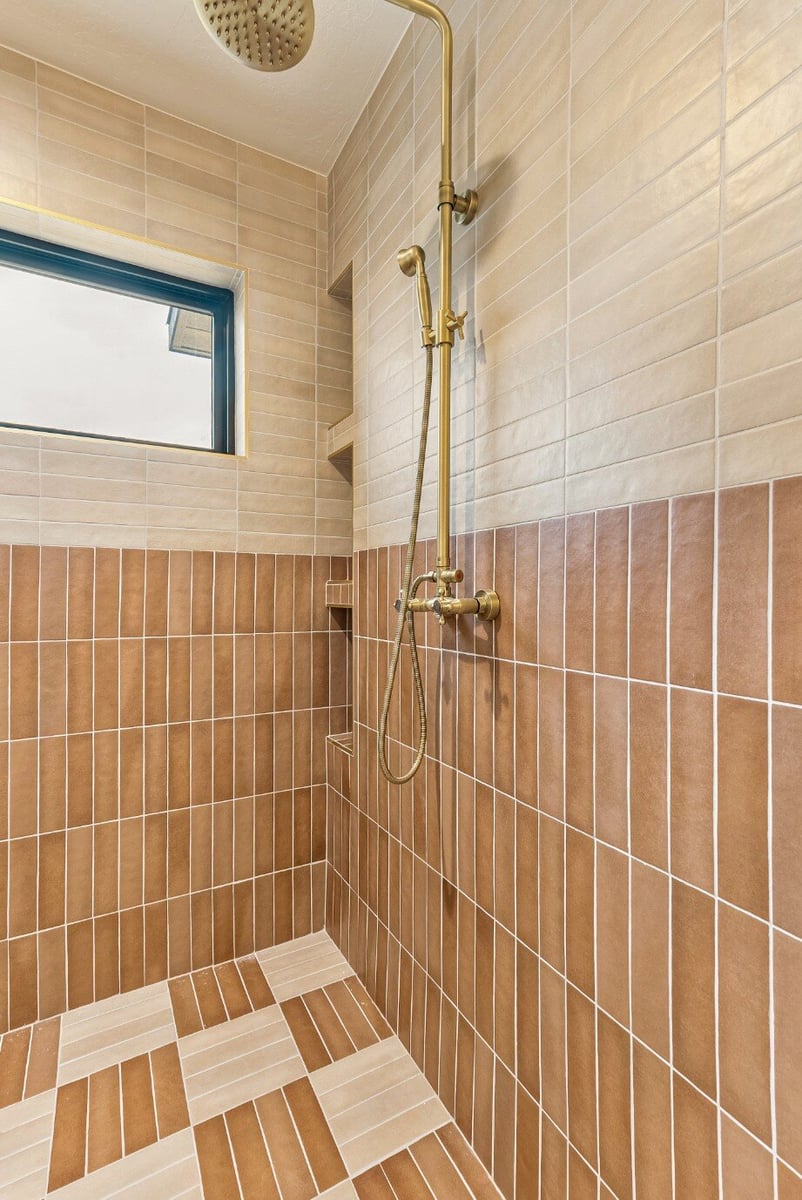 Inside the Master Bathroom Walk-in Shower with Checkered Tile Flooring, Tile Siding, and Window in Bear Lake Custom Home by 10X Builders