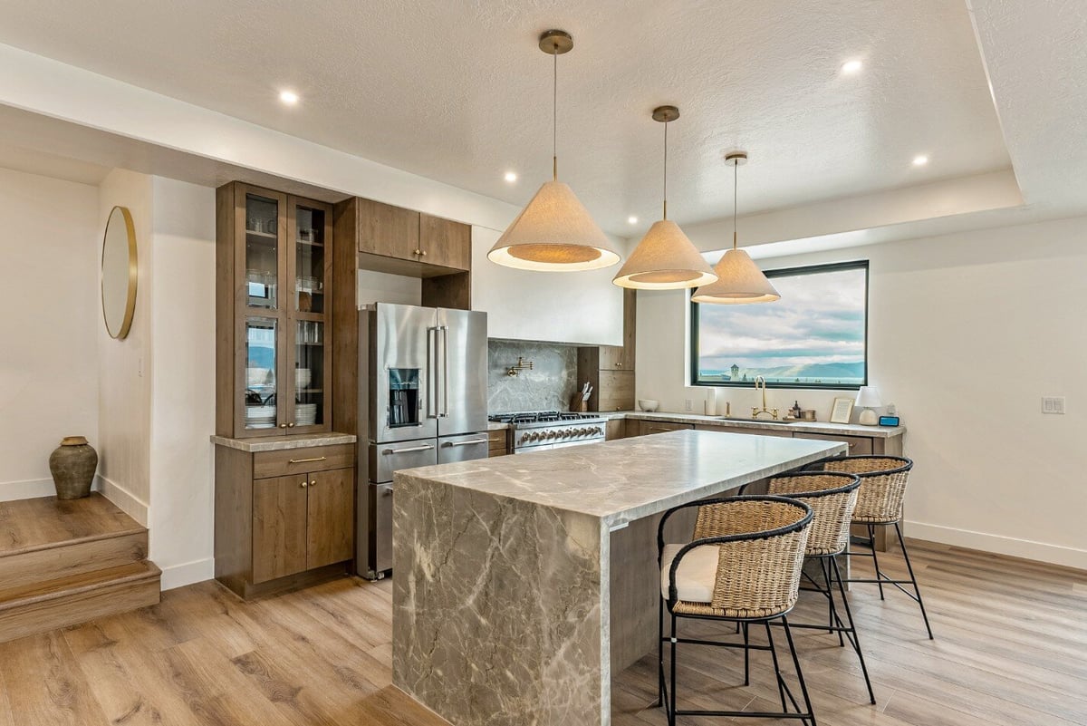 Kitchen Island with Barstools and View Out of Over-The-Sink Window in Bear Lake Custom Home by 10X Builders