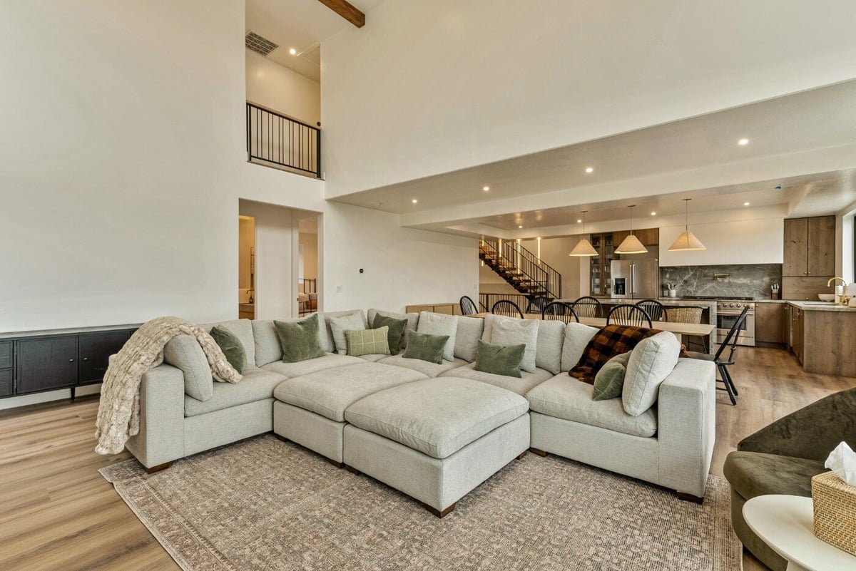 Large Gray Sectional in Living Room and View of Kitchen and Catwalk in Bear Lake Custom Home by 10X Builders