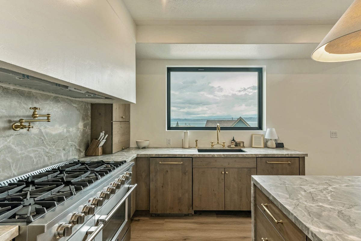 View of Kitchen Sink with Gas Stove on the Left Side in Bear Lake Custom Home by 10X Builders