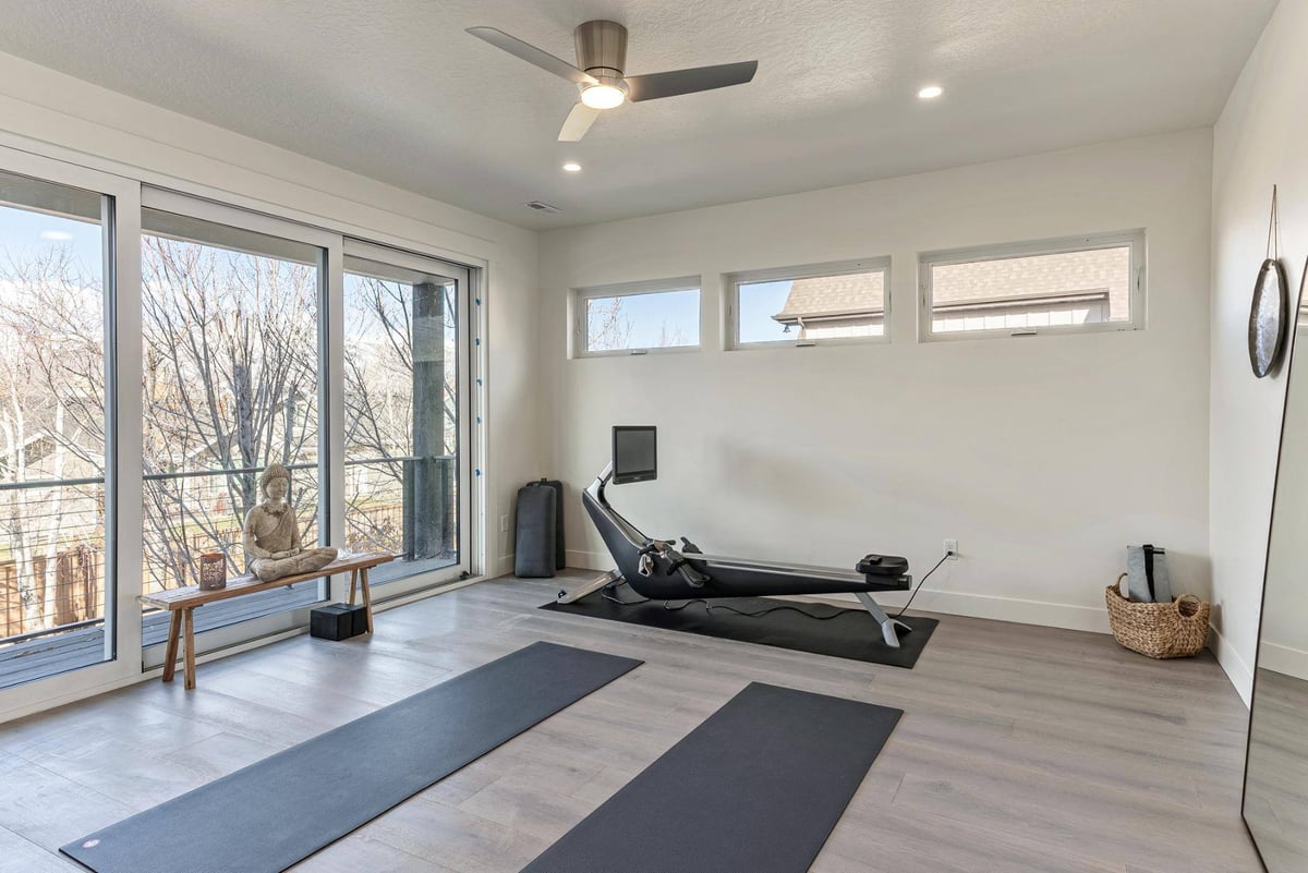 Home Gym with Row Machine, Floor to Ceiling Windows, and Balcony in Remodeled Utah Home