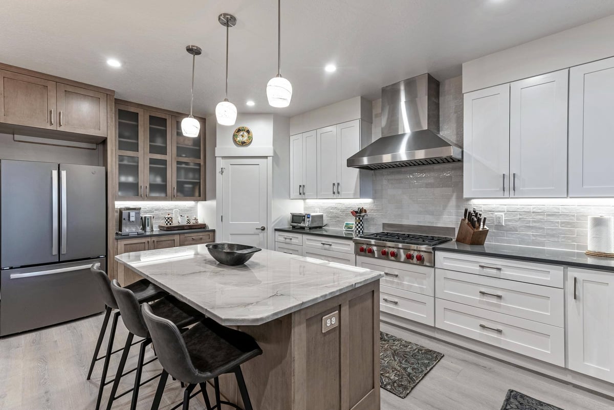 Kitchen Island with Barstools, Gas Stovetop, Silver Fridge in Remodeled Utah Home